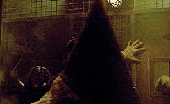 El monstruo con cabeza de pirámide caminando en dirección hacia una de las protagonistas de la saga Silent Hill.- Blog Hola Telcel