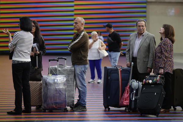 Personas esperan en el aeropuerto internacional Simón Bolívar